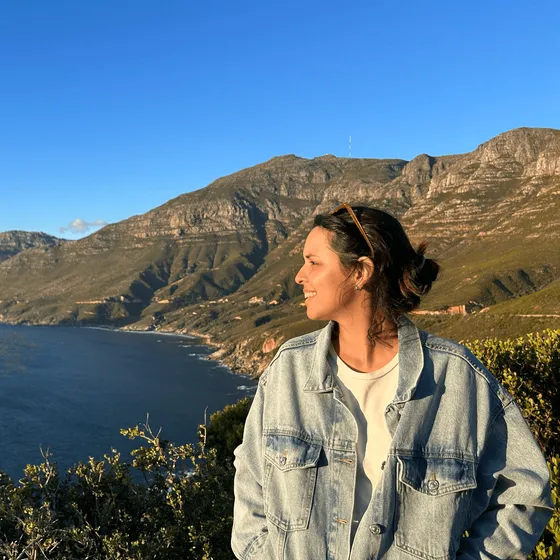 Vanessa standing on a cliff above the sea, looking into the distance