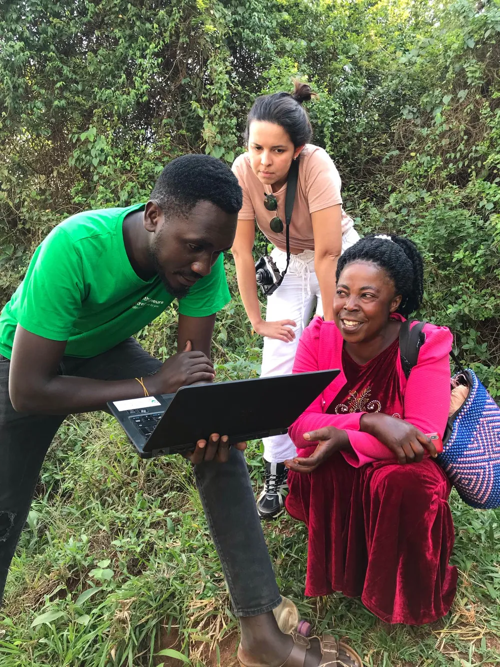 Community health workers gathered around a laptop during a field session